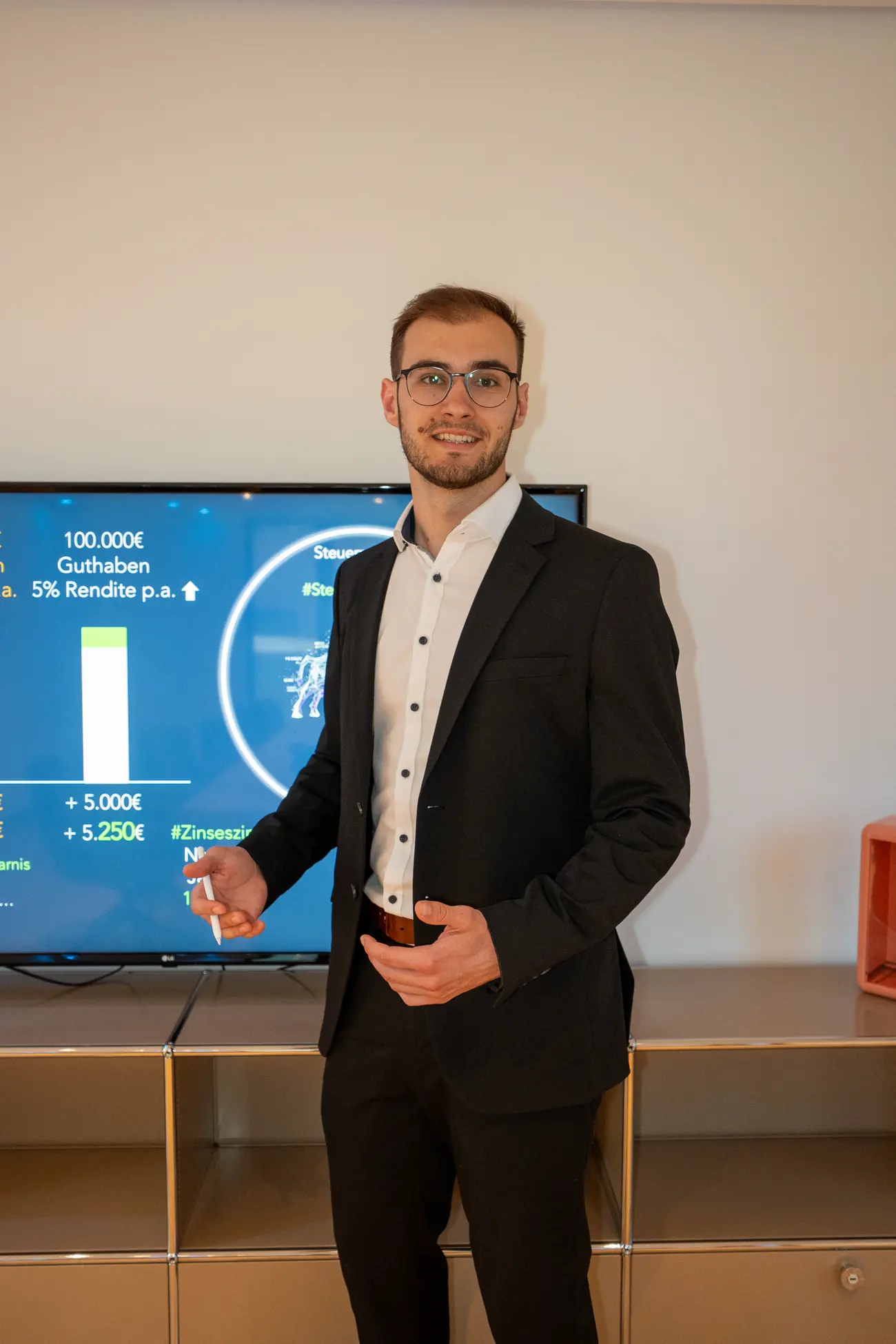 Lukas Sosnowski erklärt Finanzthemen vor einem Bildschirm